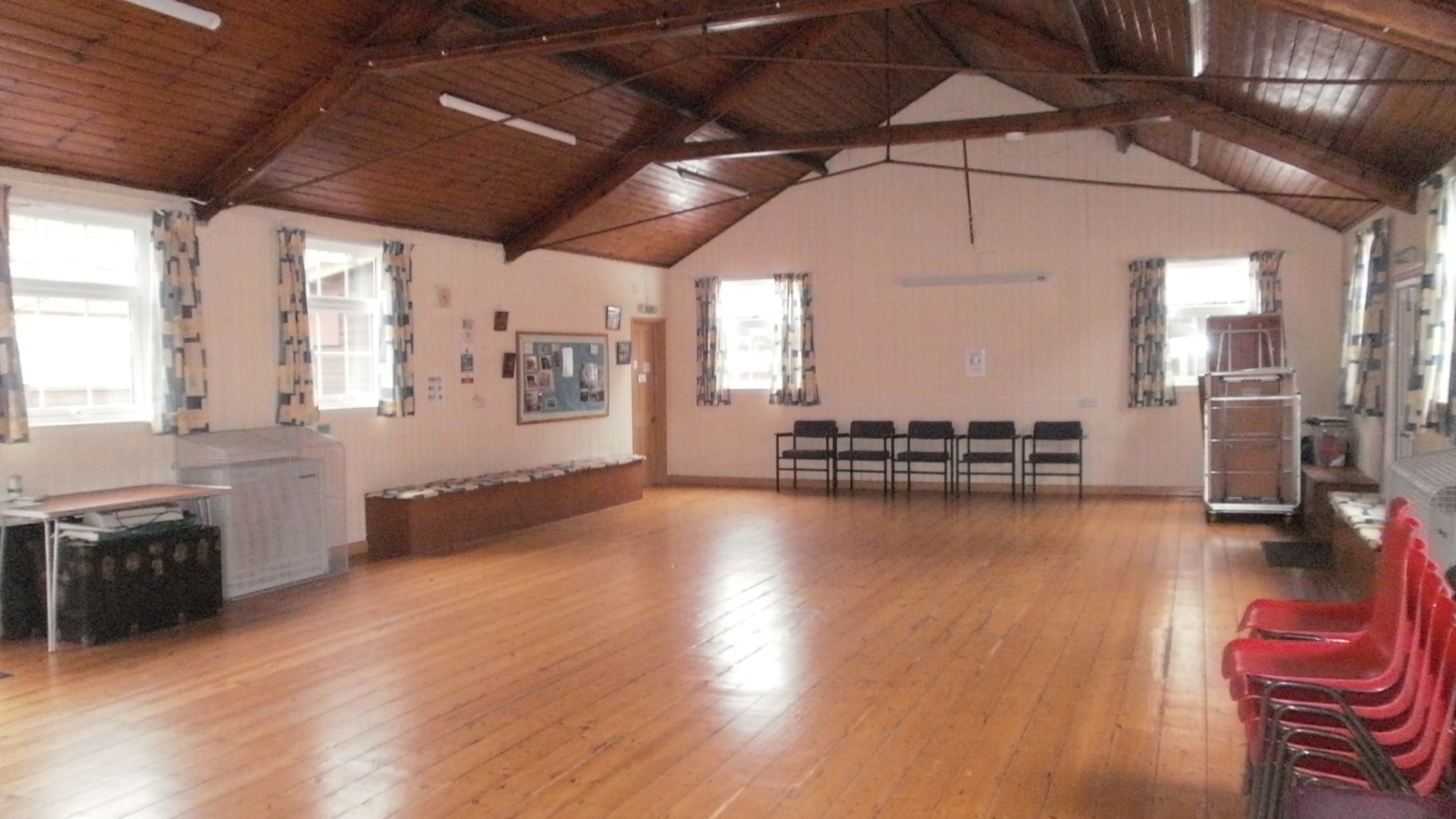 Photo of Yeovil Guide HQ main hall showing light and spacious hall, with chairs and tables stacked at the corners