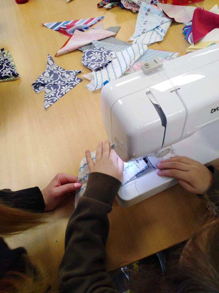 Brownie using a sewing machine for the first time to make the bunting