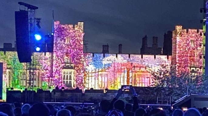 Girlguiding volunteers at the coronation concert looking at Windsor castle lit up in coloured lights