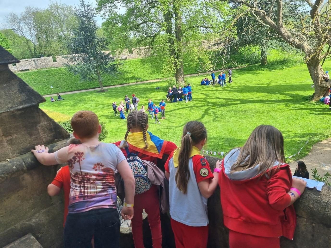 Rainbows overlook activities on the lawn from a vantage point over the Bishops Palace gardens in Wells