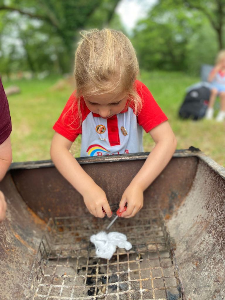Photo of a young Rainbow lighting a fire