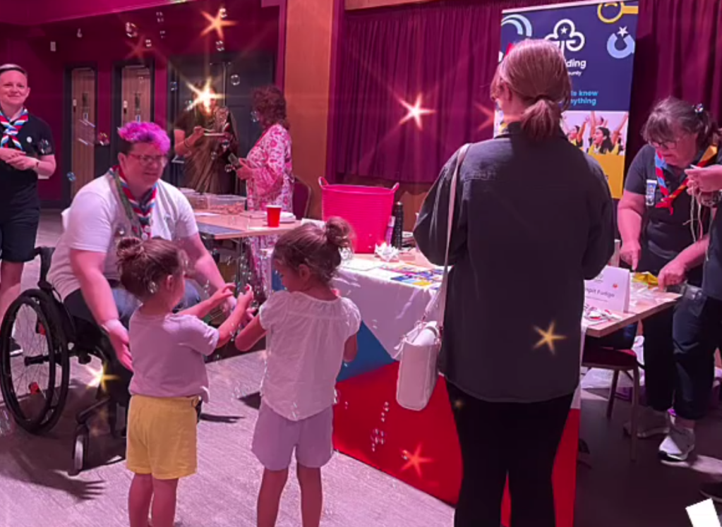 Two young girls enjoy the bubble making machine at the Girlguiding stall