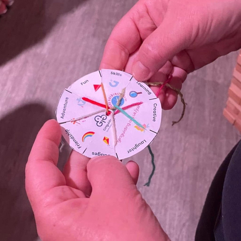 Photo of a friendship bracelet with Girlguding logo and icons