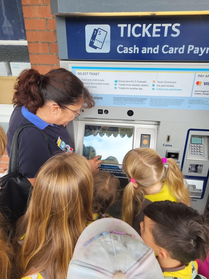 Brownies learn how ticket machines work with their leader