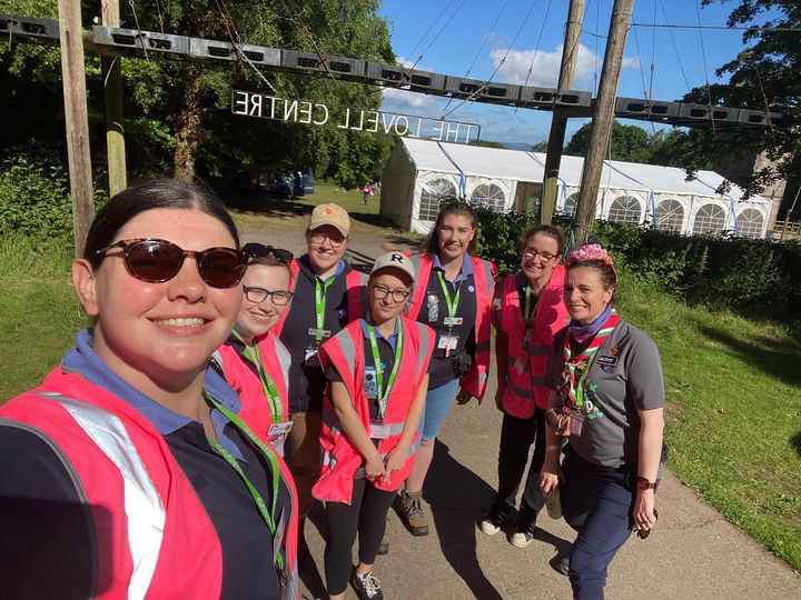 A group of our wonderful adult volunteers take a selfie in their Girlguiding uniforms and bright pink hi-vis vests