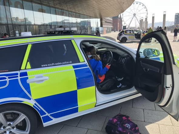 A Guide photographed at the wheel of a police car in Cardiff Cityscape Adventure